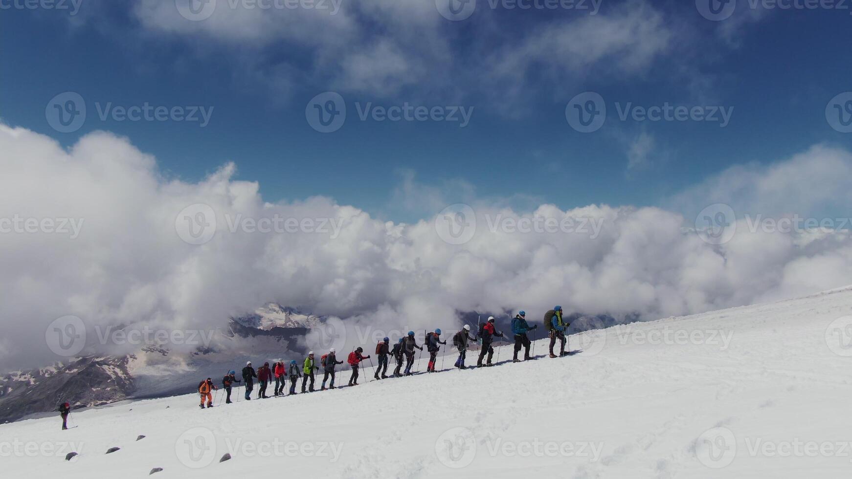 A group of people standing on a snowy mountain photo
