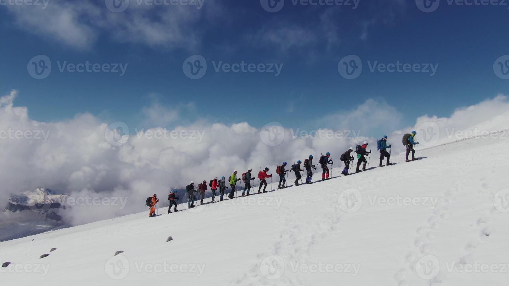 A group of people standing on a snowy mountain photo