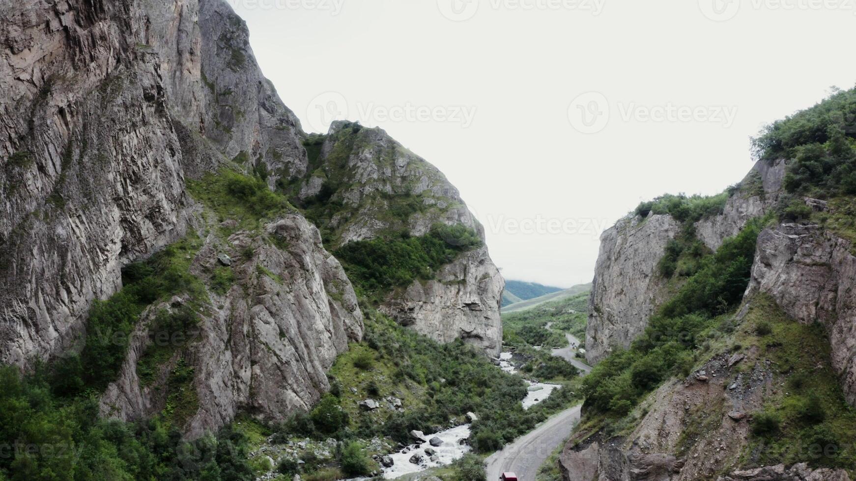 A man is riding a motorcycle down a narrow road photo