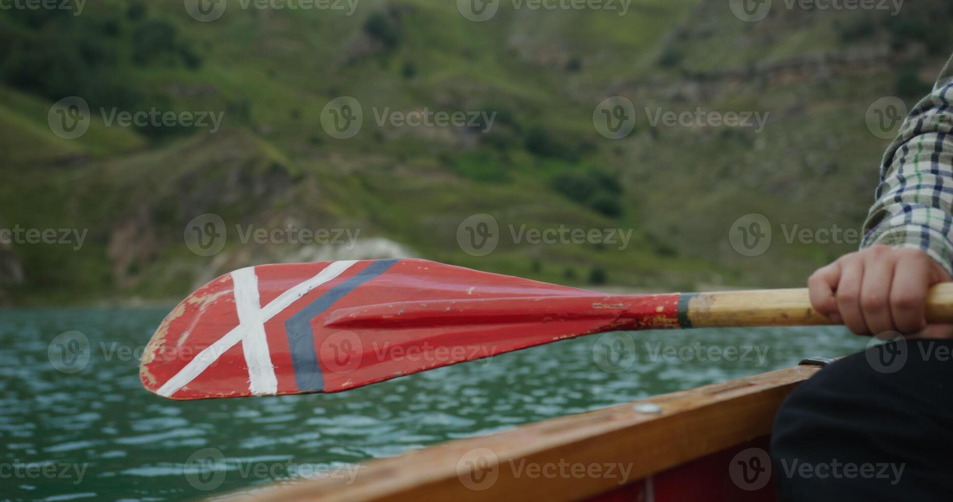 A man paddles a canoe on a lake photo