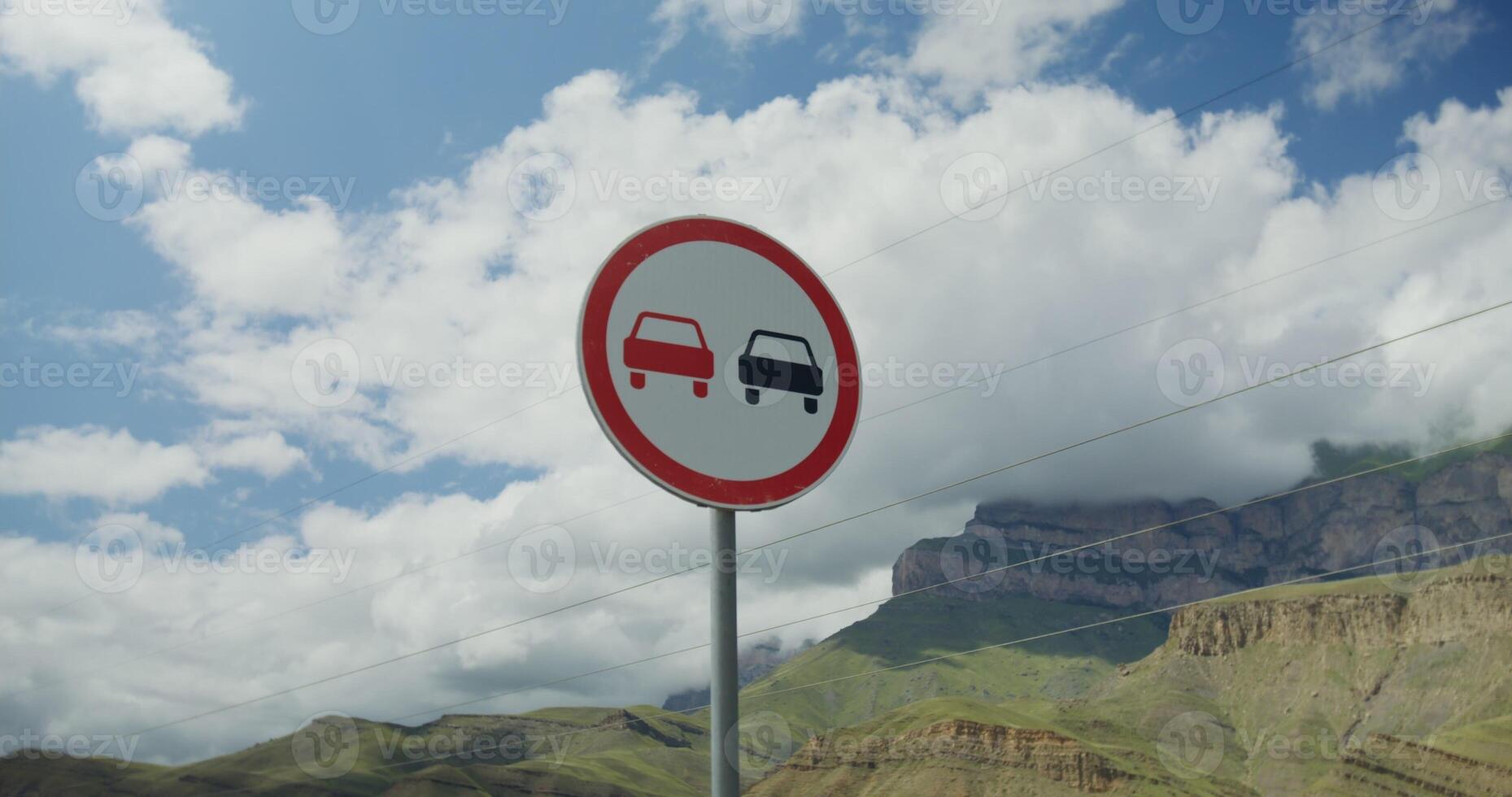 A no parking sign on a road with mountains in the background photo