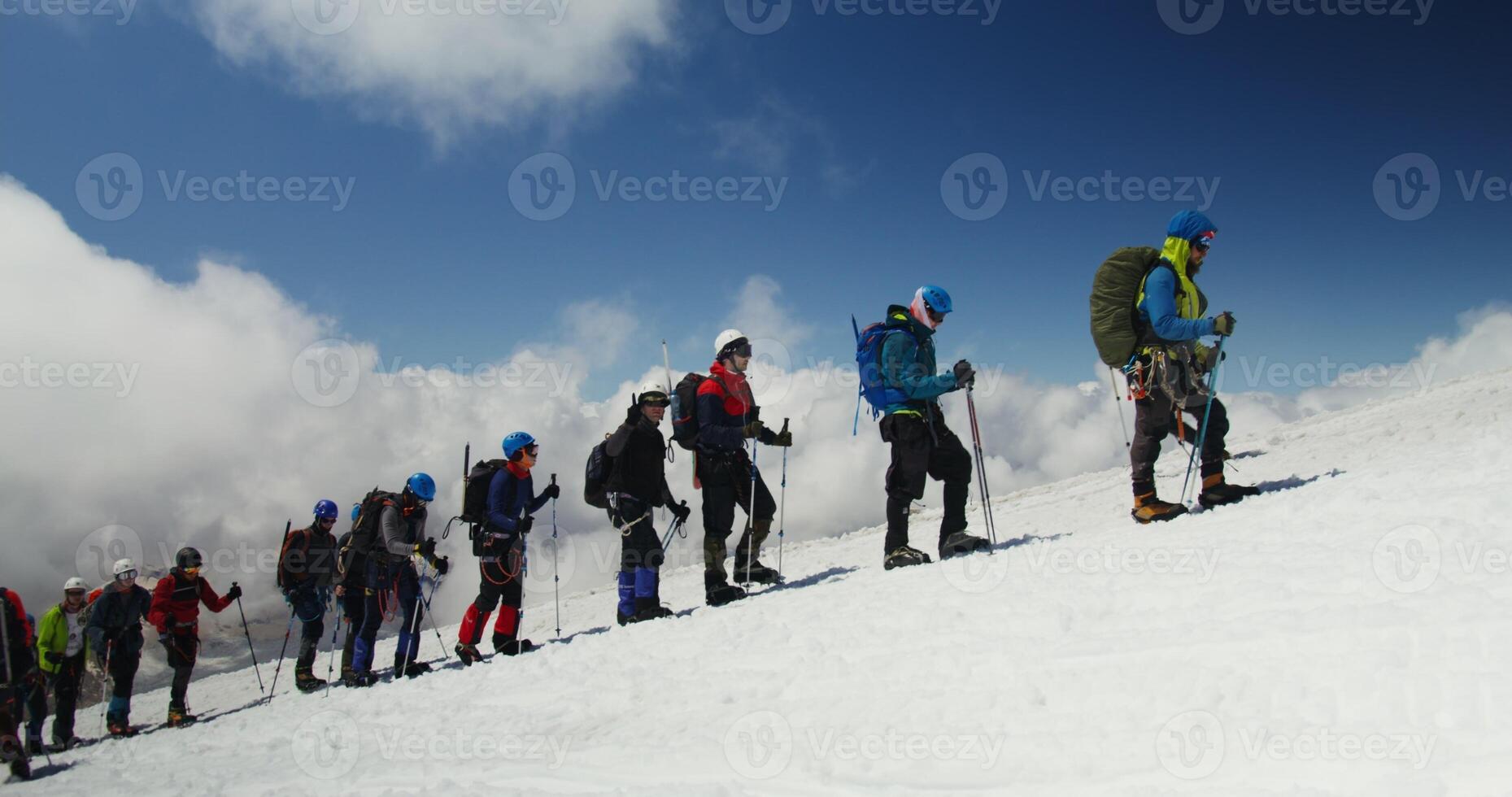 A group of people standing on a snow covered slope photo
