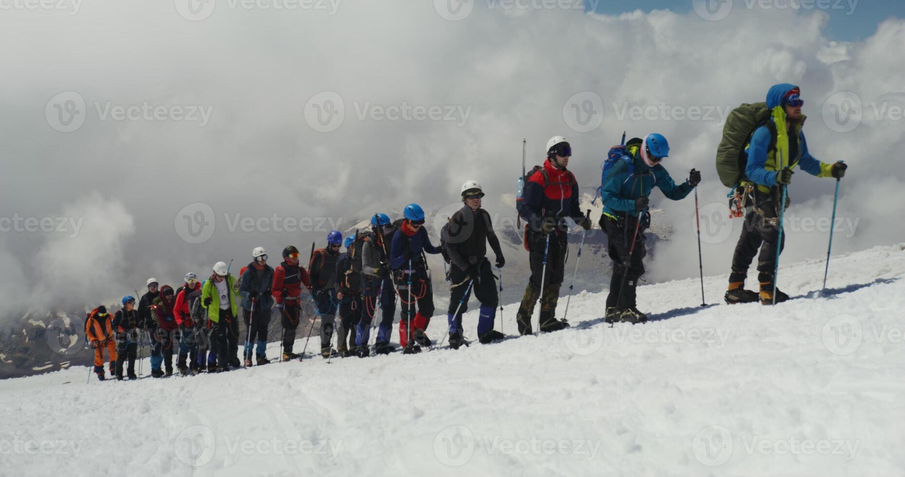A group of people standing on a snowy mountain photo