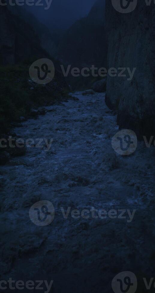 Mountain river, seething with a strong stream among the rocks, filming at night. Vertical photo
