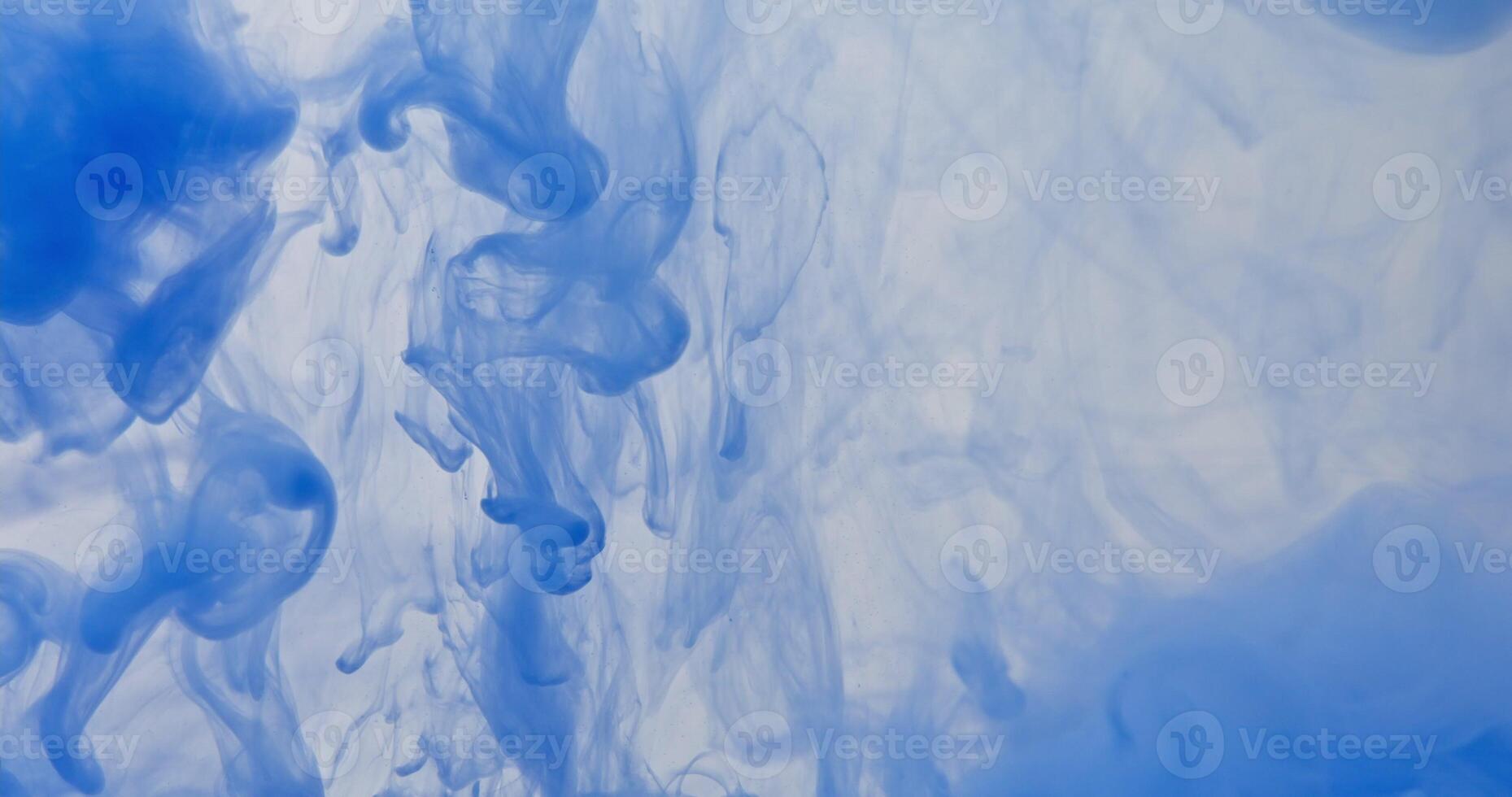 Blue ink in water with a blue background photo