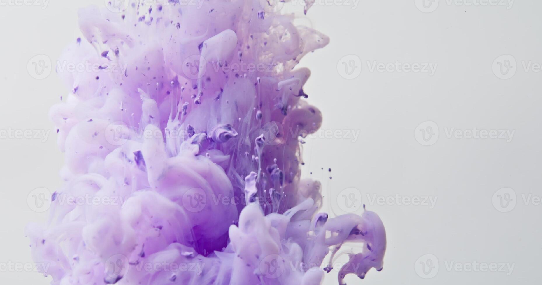 The paint bursts into the water with force, large bright drops float up photo