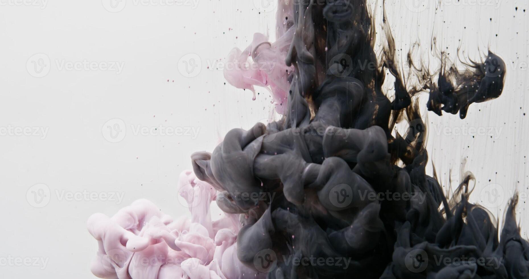 Two colors of paint forcefully rush into the water, swirl and spread photo