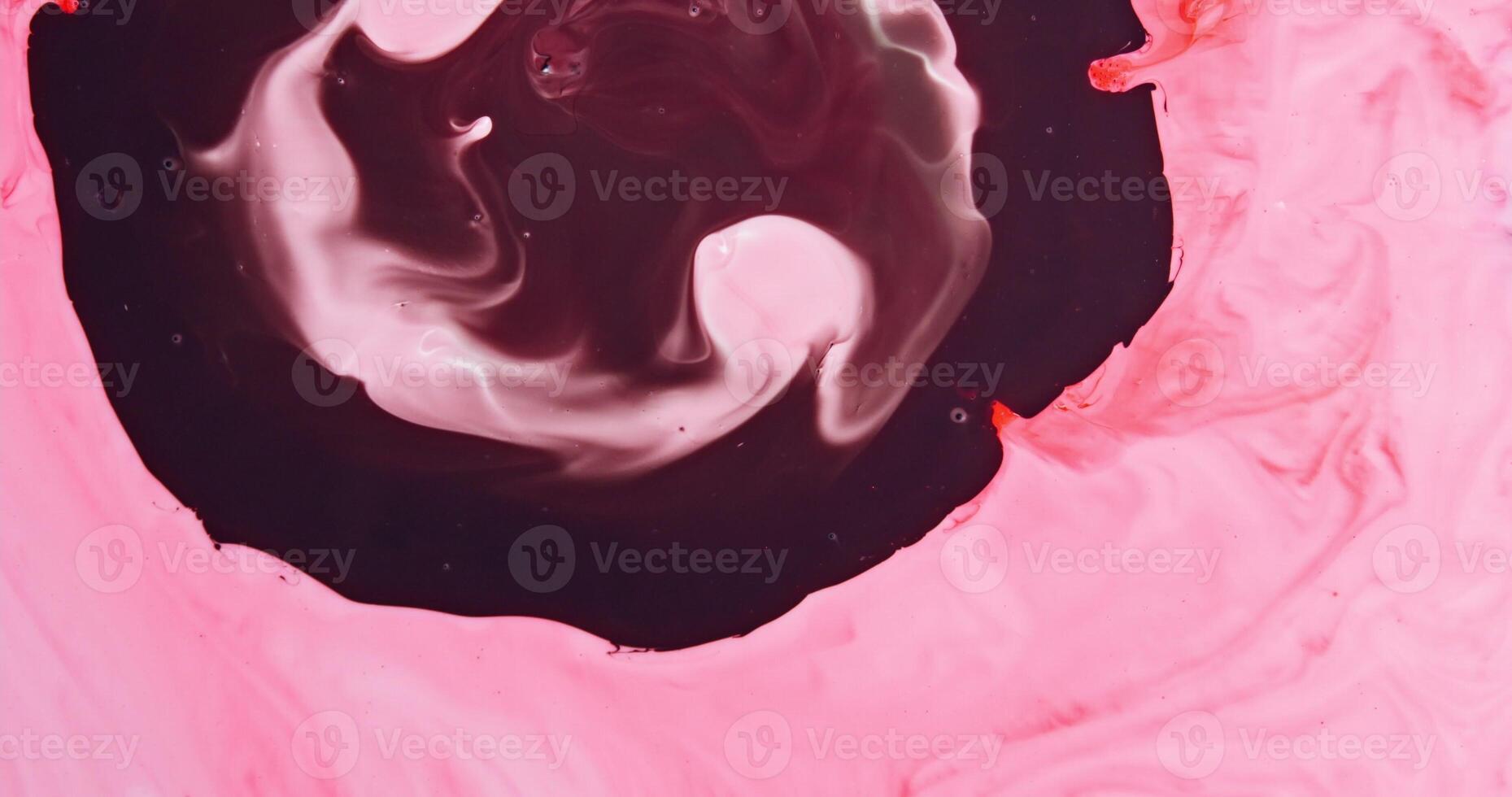A pink and black swirl on a surface photo