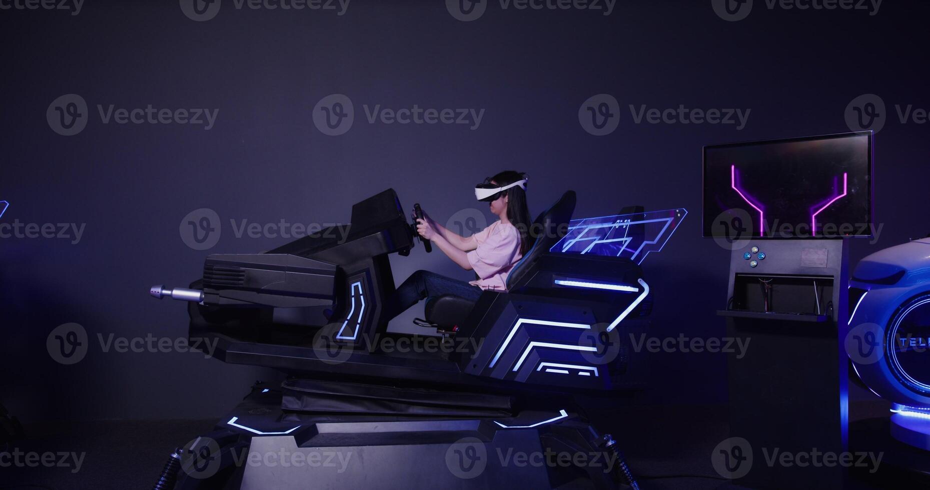 A woman in a virtual reality headset is sitting in a chair photo