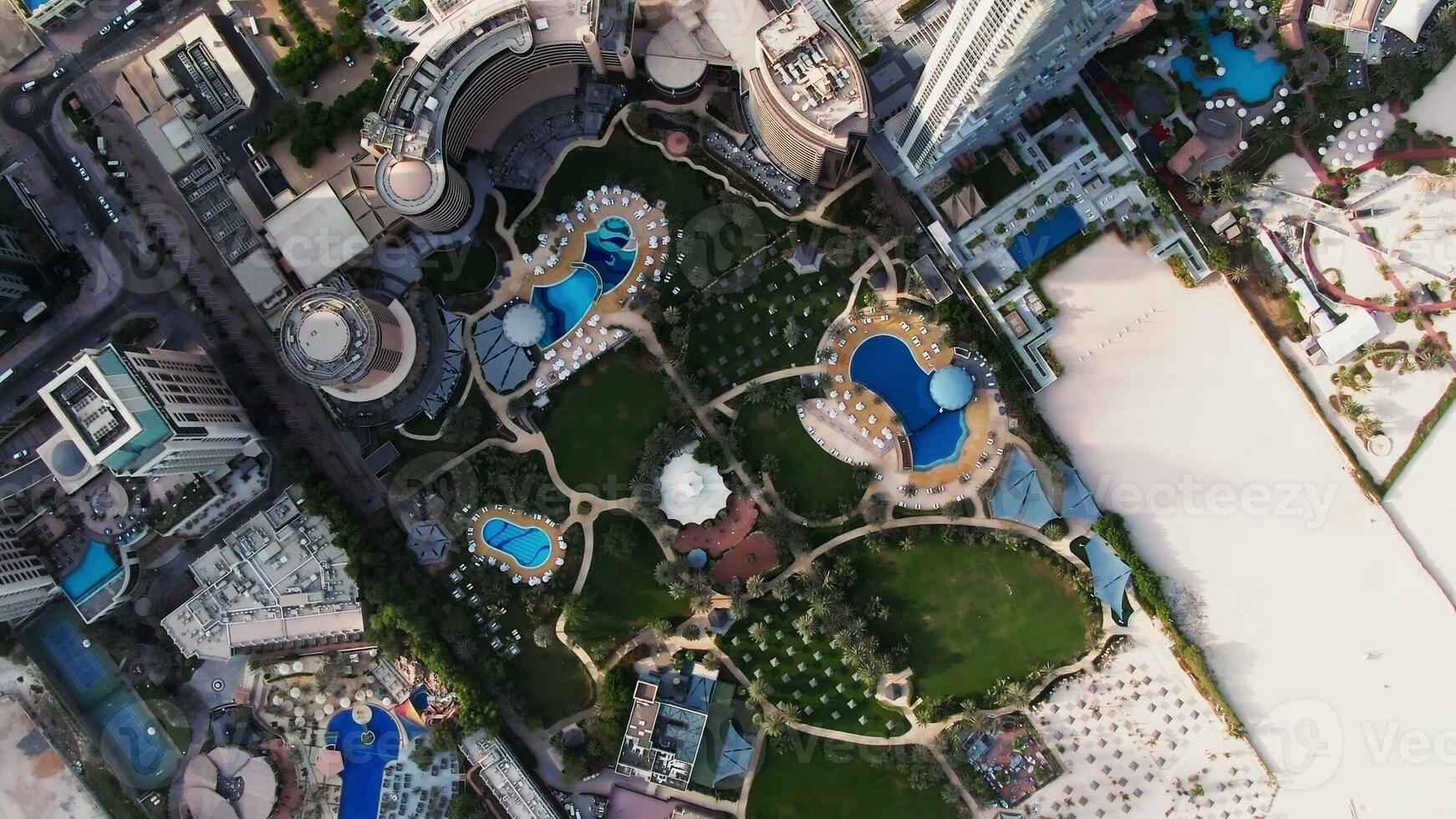 An aerial view of a city with a pool and a hotel photo