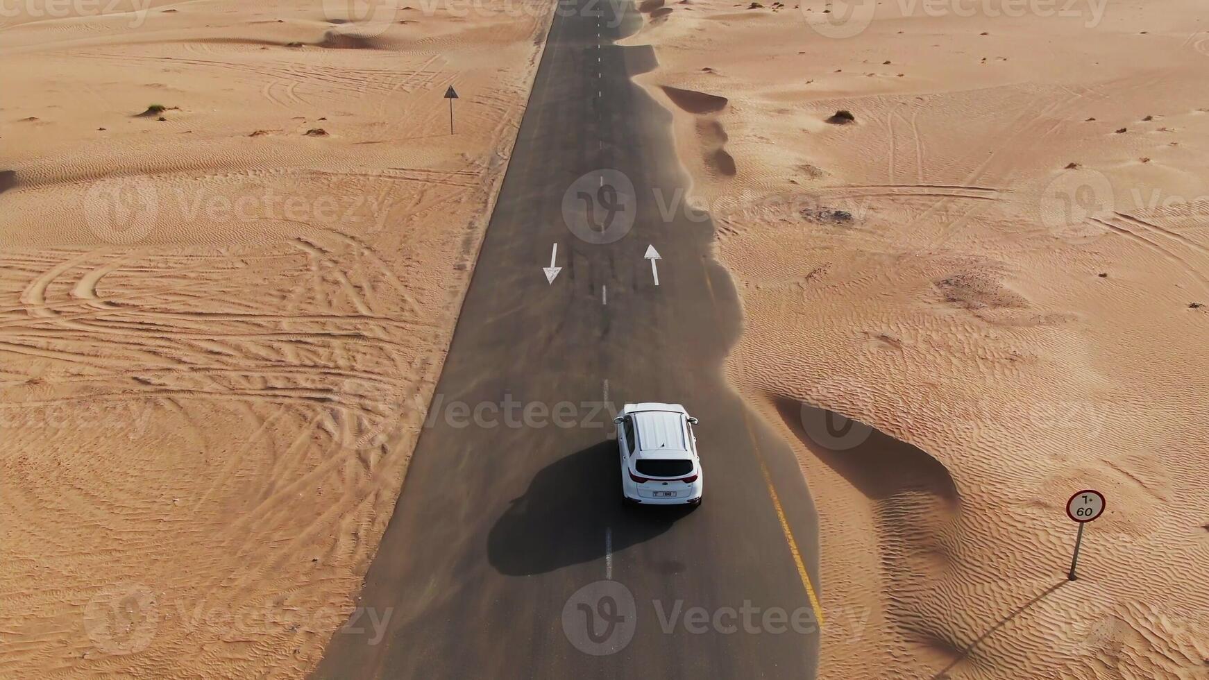 A car driving down a desert road in the middle of the desert photo