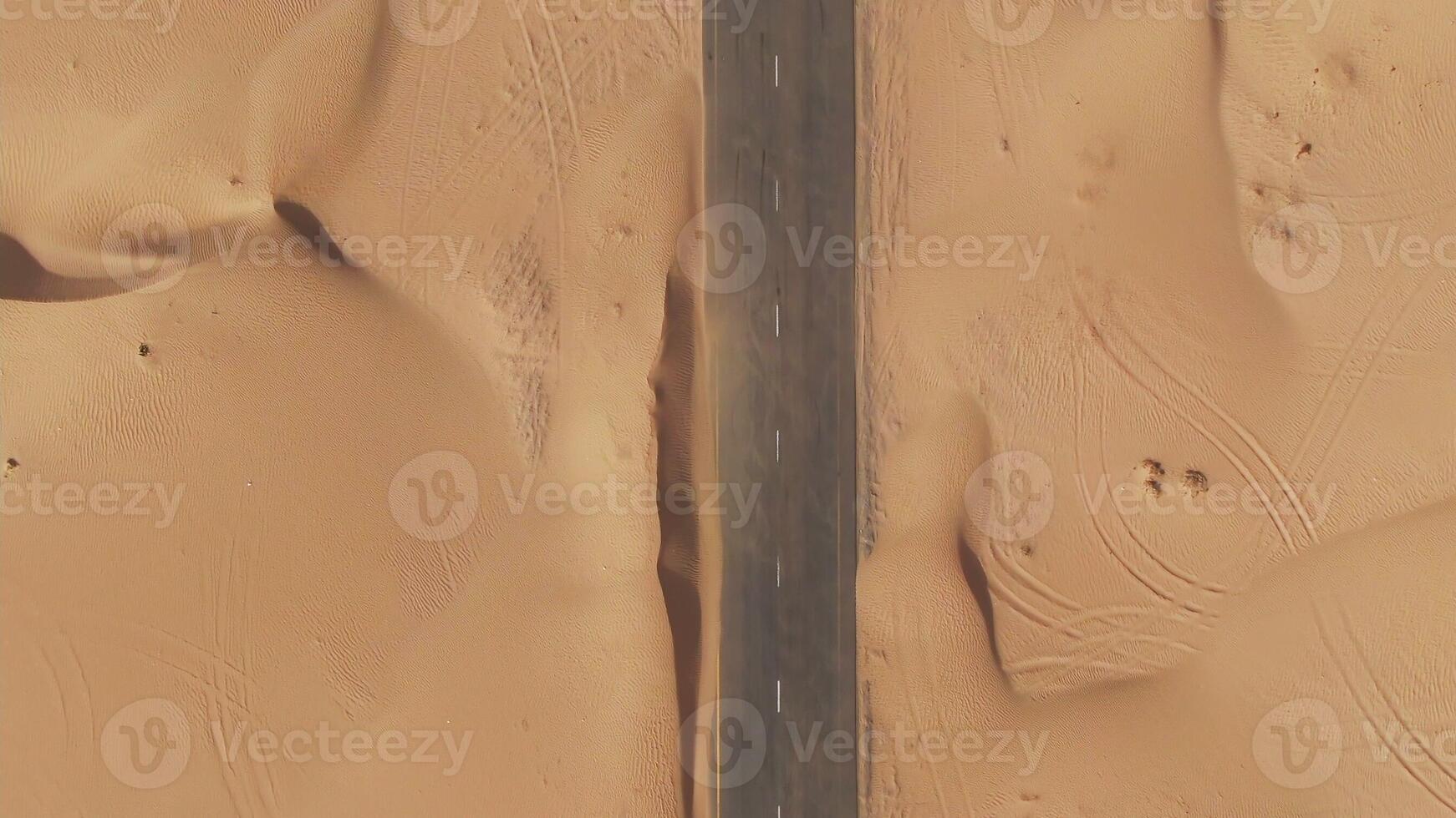 Aerial view of desert paved road buried by sand dunes. Dubai, United Arab Emirates. Daylight drone shooting. photo
