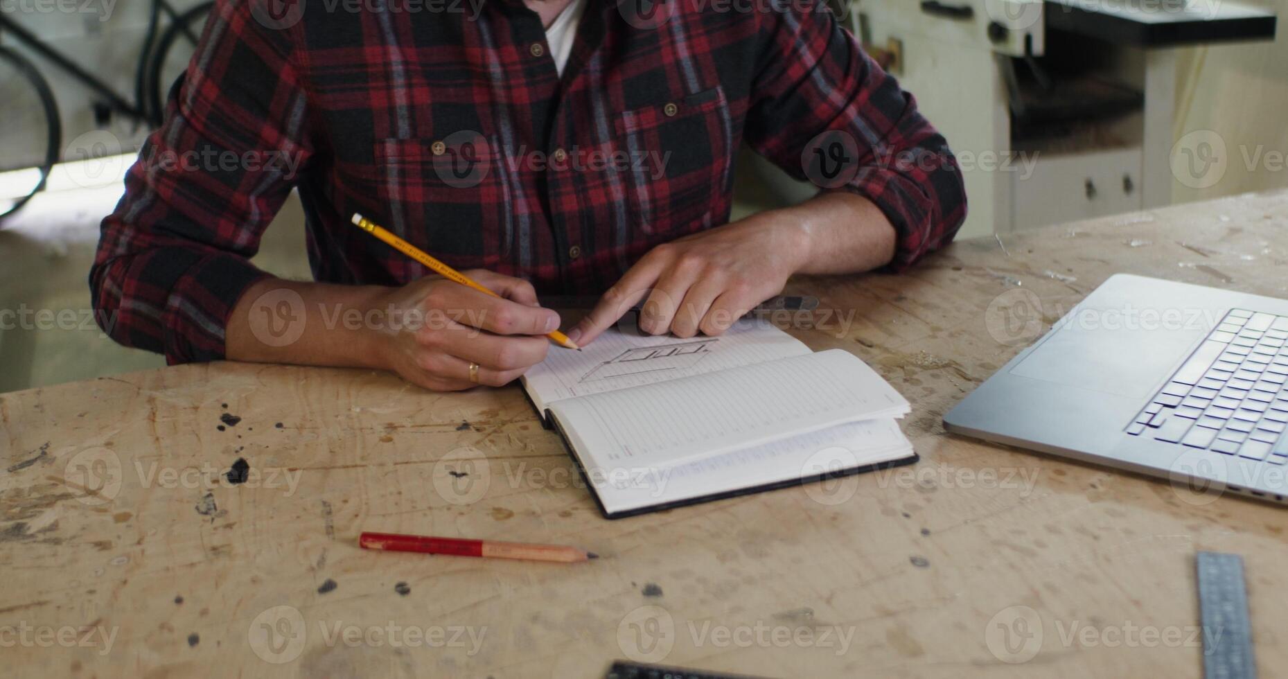 A man sitting at a table writing in a notebook photo