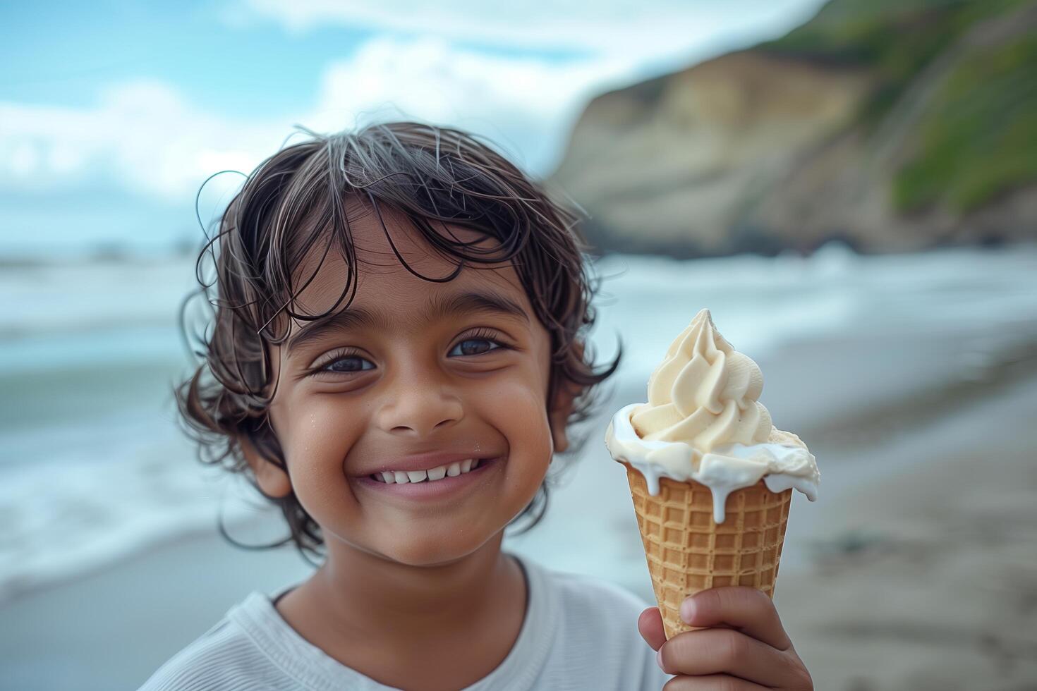A young boy smiles while holding an ice cream cone photo
