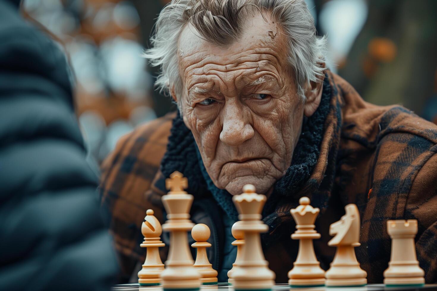 An older man playing chess with another person photo