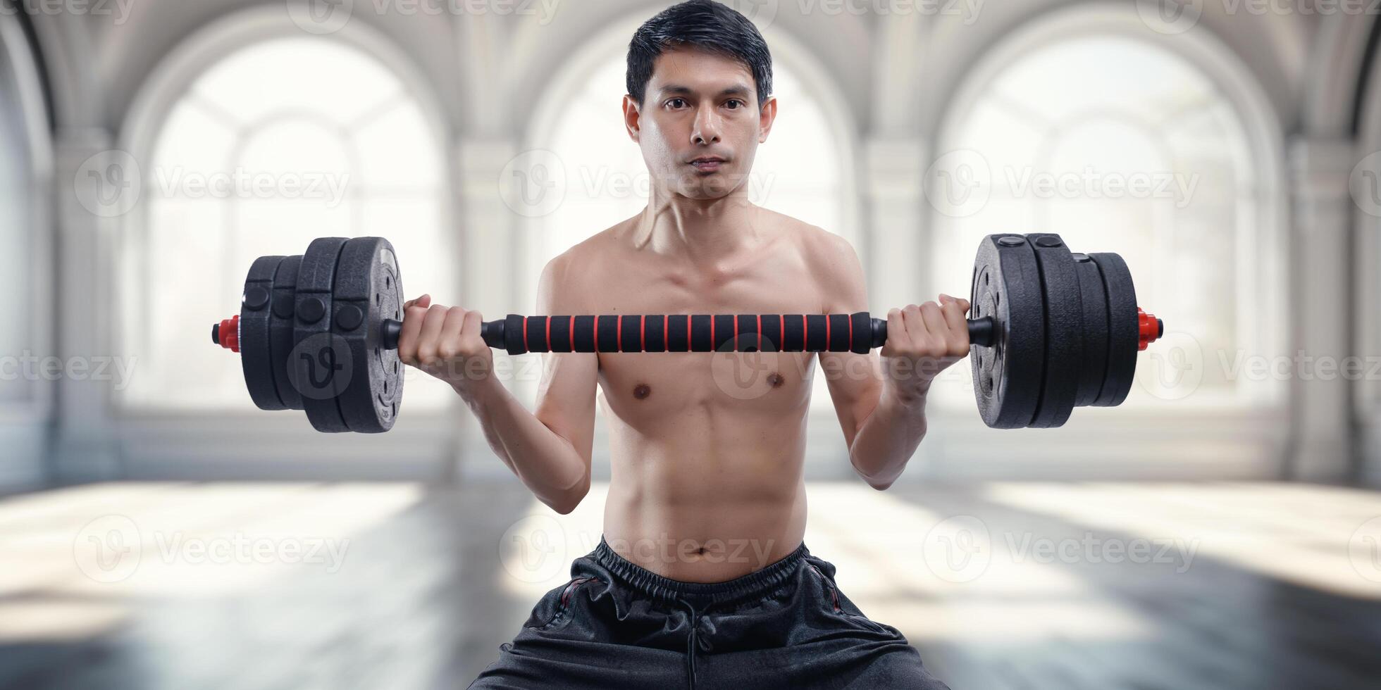 Young Man Lifting Dumbbells in Modern Fitness Environment photo