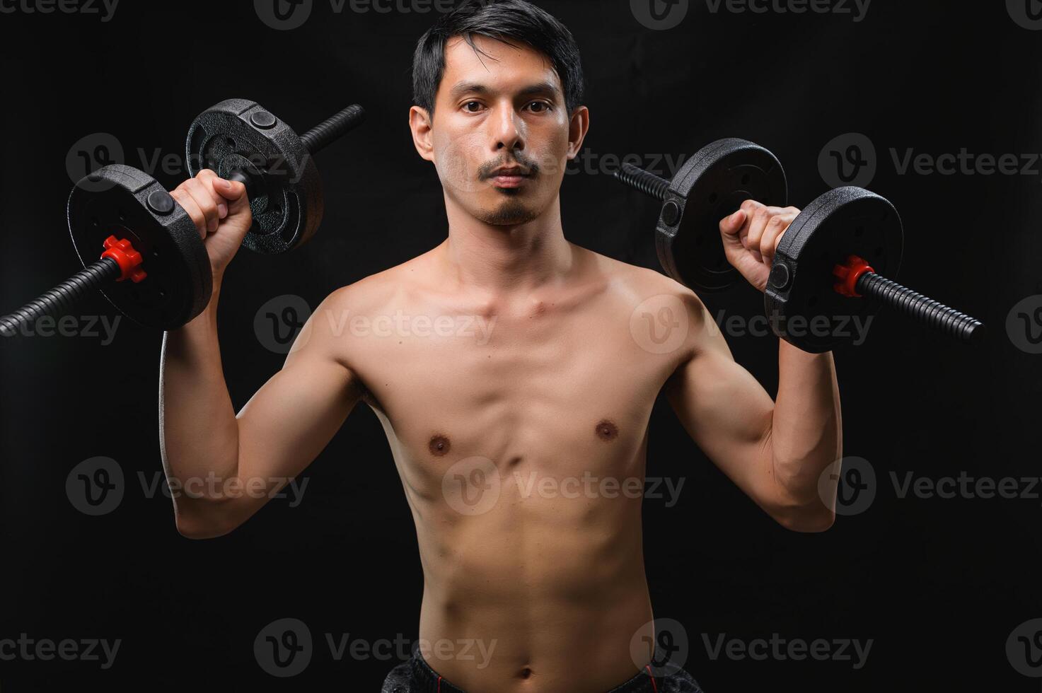 Man Lifting Dumbbells in a Studio for Health and Strength Training photo