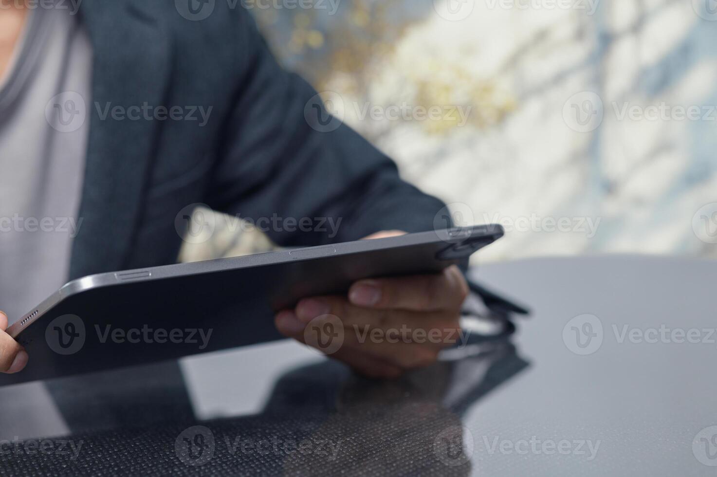 Person Using Tablet Outdoors with Nature Background in Soft Light photo