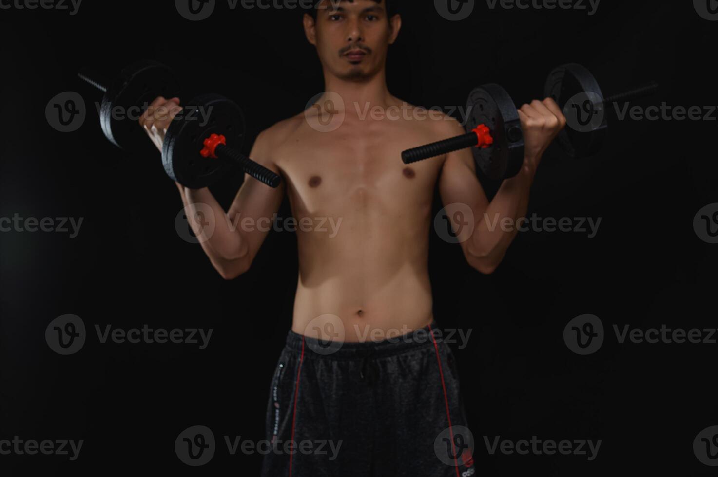Determined Man Lifting Dumbbells for Strength and Health Improvement photo