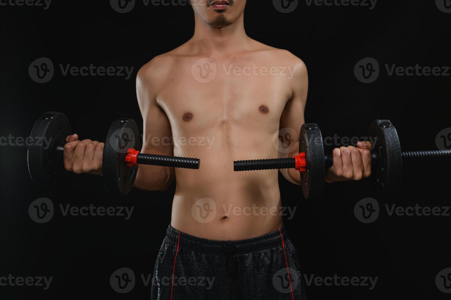 Strong Man Holding Weights in a Dark Studio Environment photo