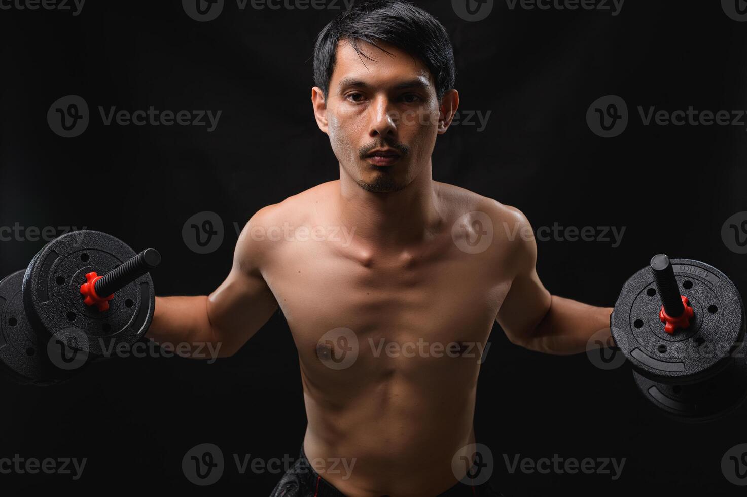 Focused Man Lifting Dumbbells to Build Strength and Improve Health photo