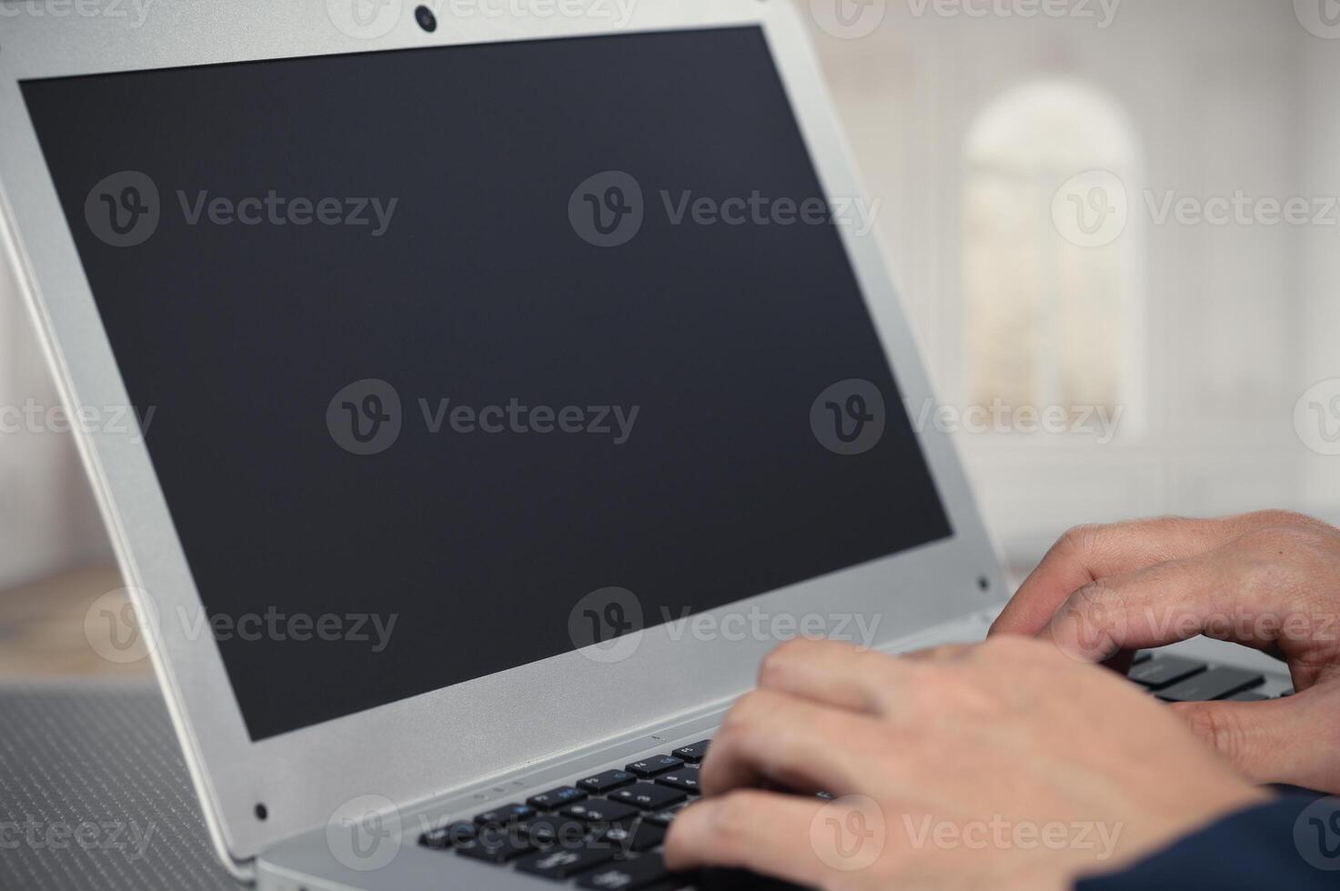 Hands Typing on a Laptop with Blank Screen in Minimalist Space photo