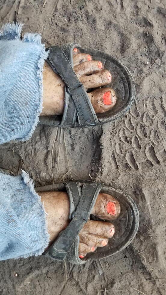 Dirty Feet with Painted Toenails wearing Sandals and Jeans, Outdoors photo