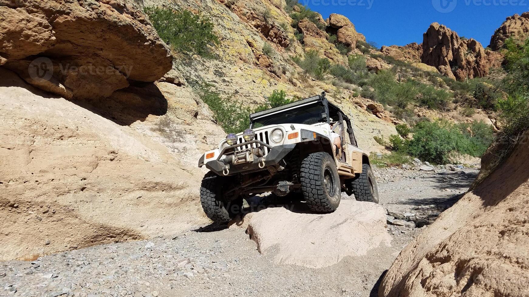 White 4x4 Vehicle Crawling over a Rock, Offroading Adventure in Arizona photo