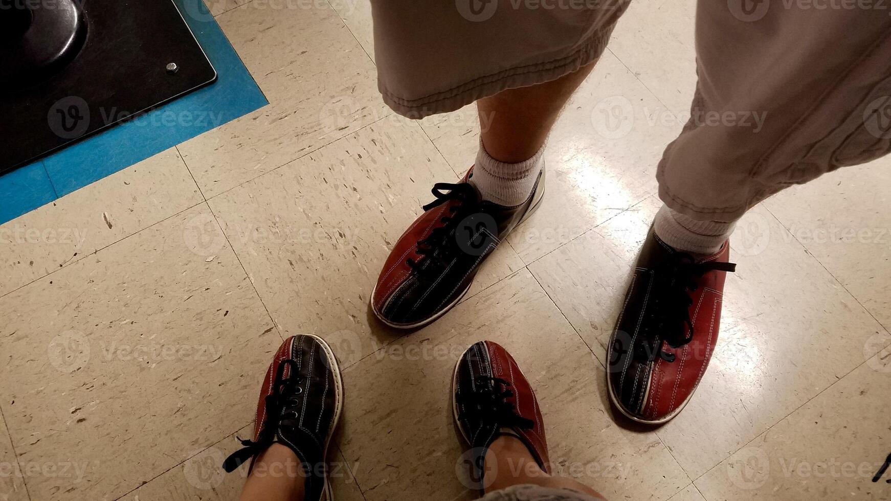 Couple Wearing Blue and Red Bowling Shoes at a Bowling Alley photo