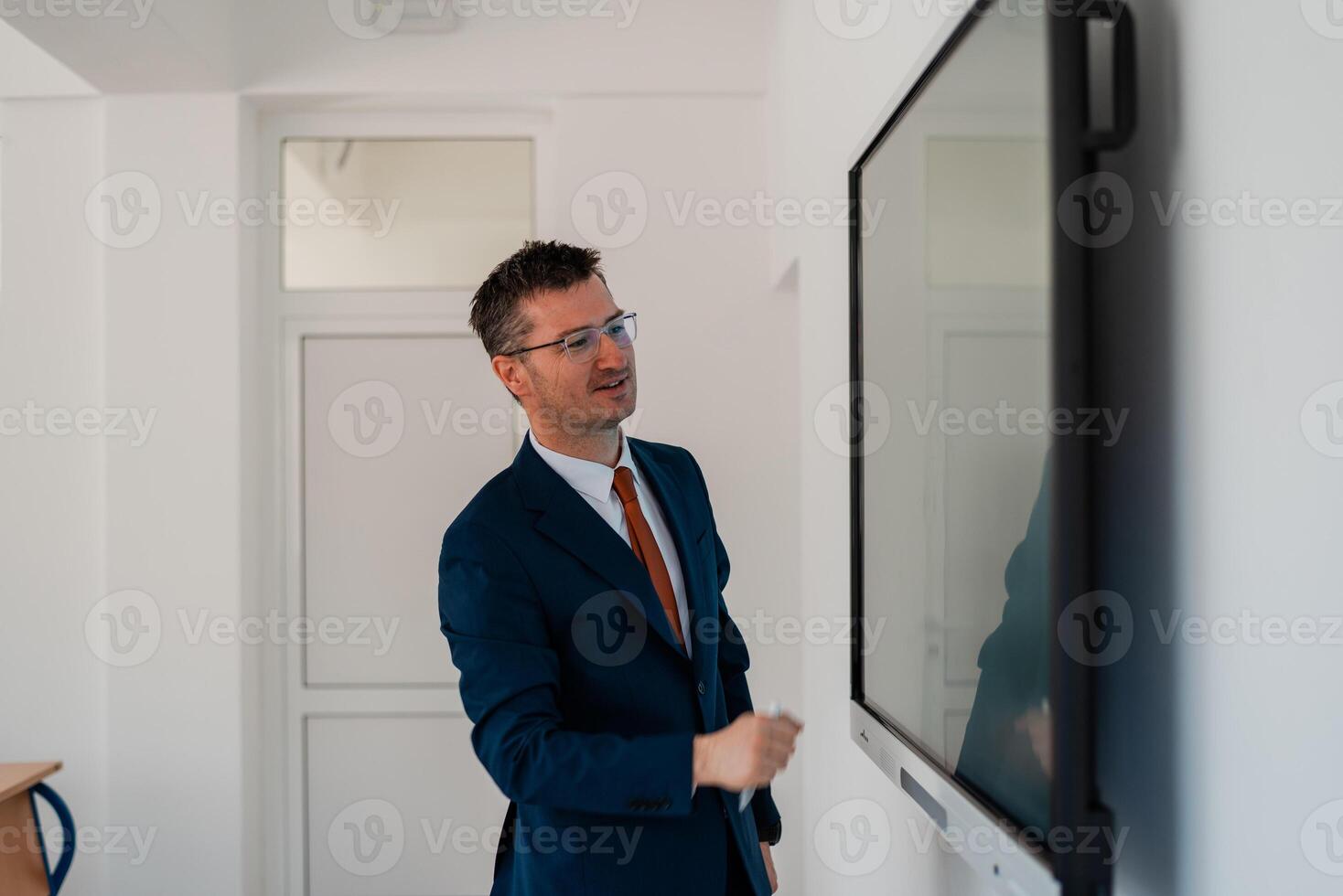 University male teacher giving lecture in the classroom or business man presenter public speaking in a conference meeting room using a display screen board. . photo