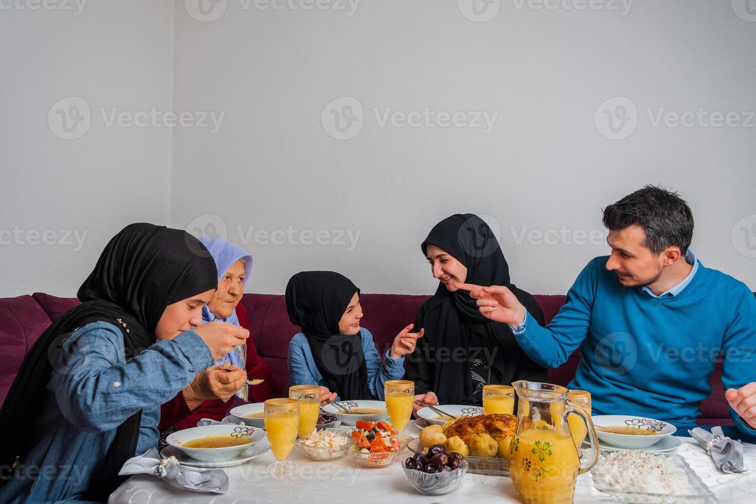 Happy Muslim family having iftar dinner during Ramadan dining table at home. photo