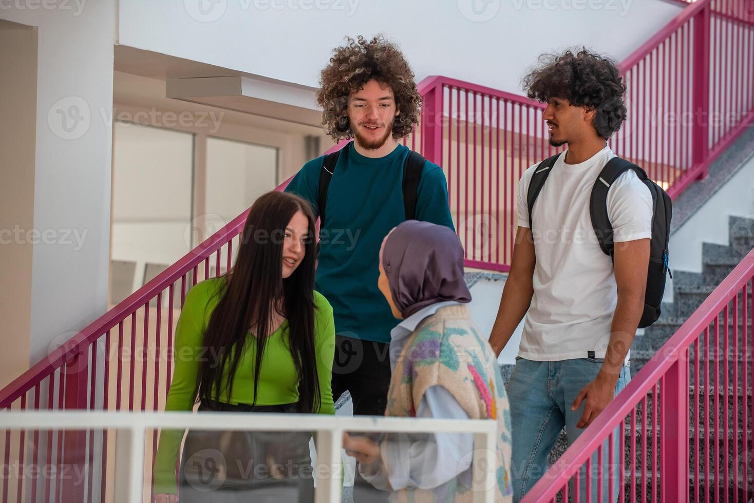 A group of happy diverse college students hanging out they are talking with each other while walking in the university hallway. photo