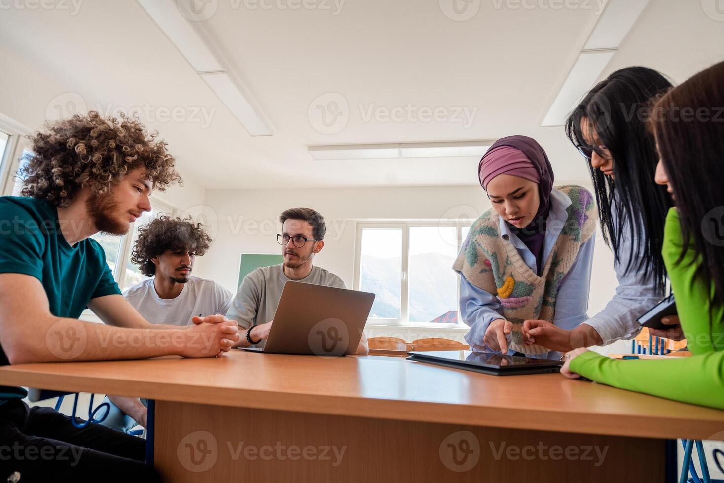 A group of diverse college students studying together or young business team working on a project plan. photo