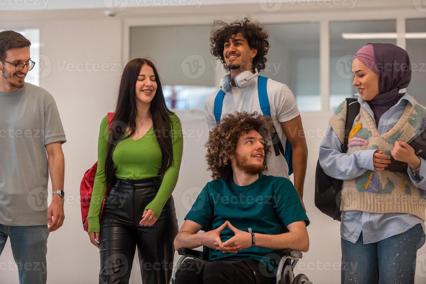 A group of happy diverse college students talking to each other while they walk in the university hallway. photo