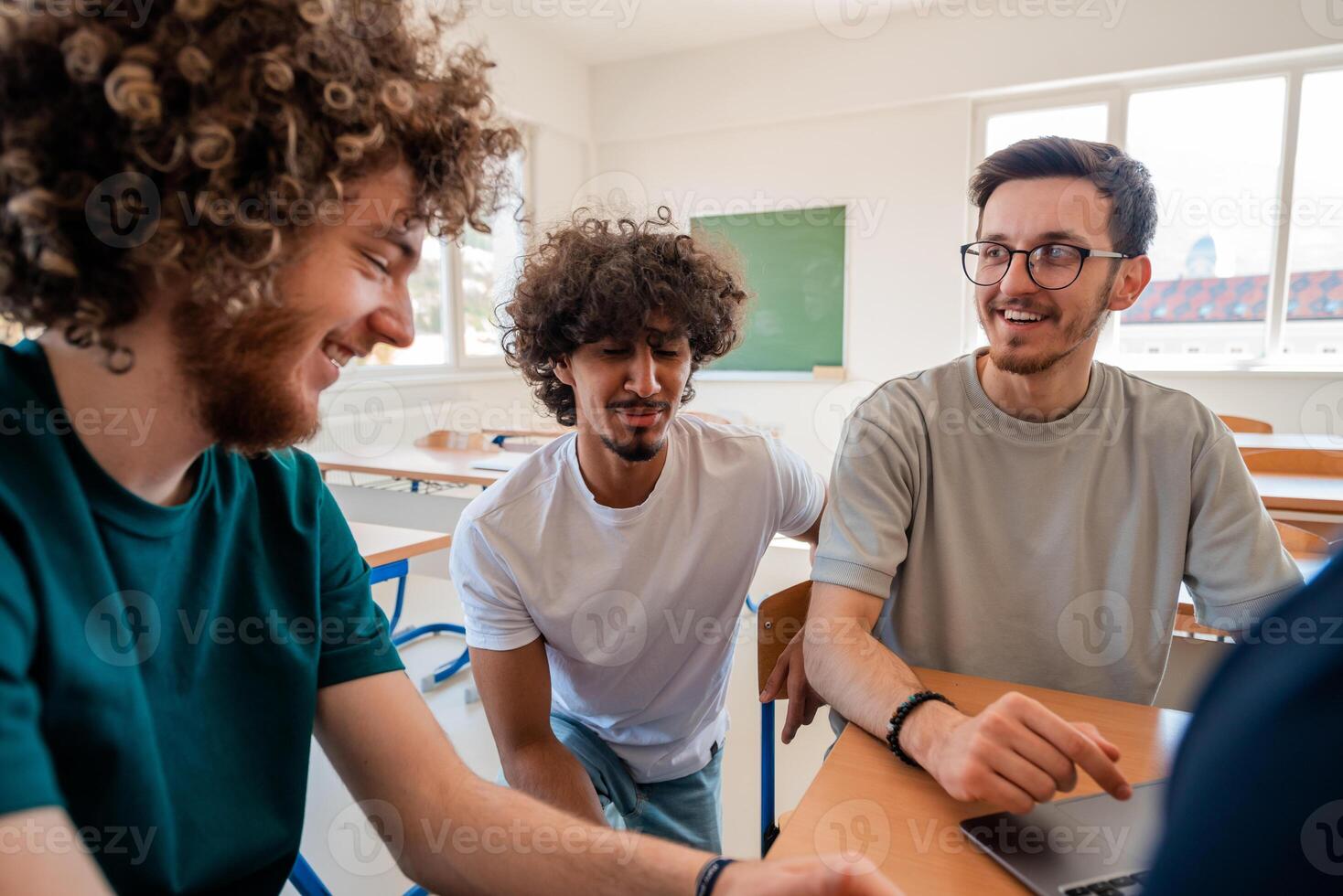 A group of happy diverse college students studying together in the classroom. photo