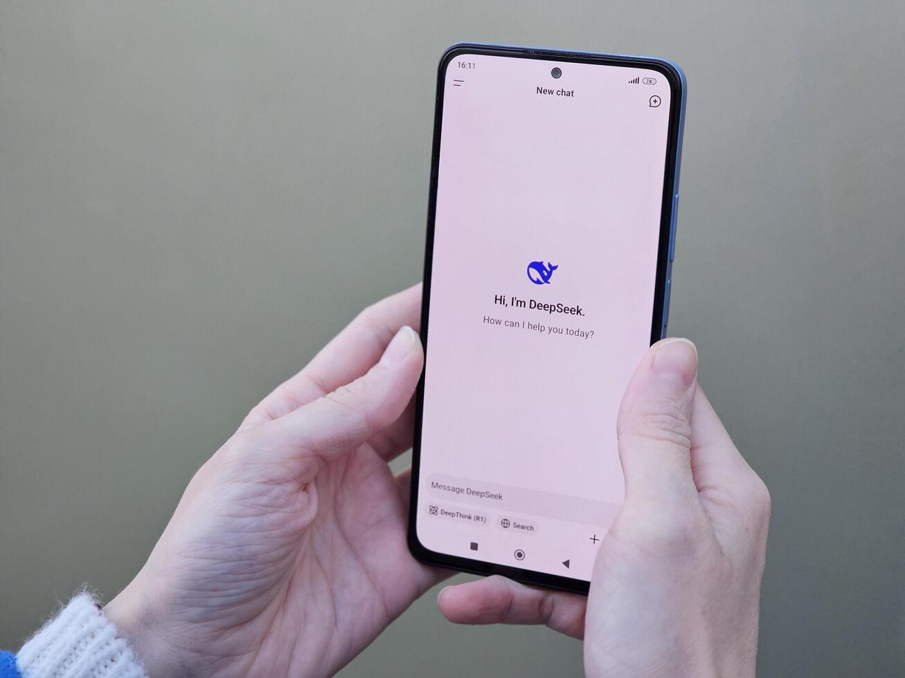 Travnik, Bosnia and Herzegovina, 02.08.2025. Close up of Asian female hands using DeepSeek app chat on phone to solve a reasoning problem on an isolated background, real photo. photo