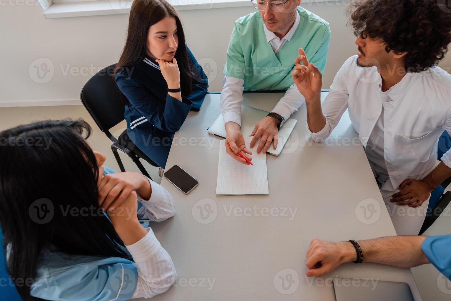 A medical team of doctors discussing and planning a work strategy at a meeting in the conference room. photo