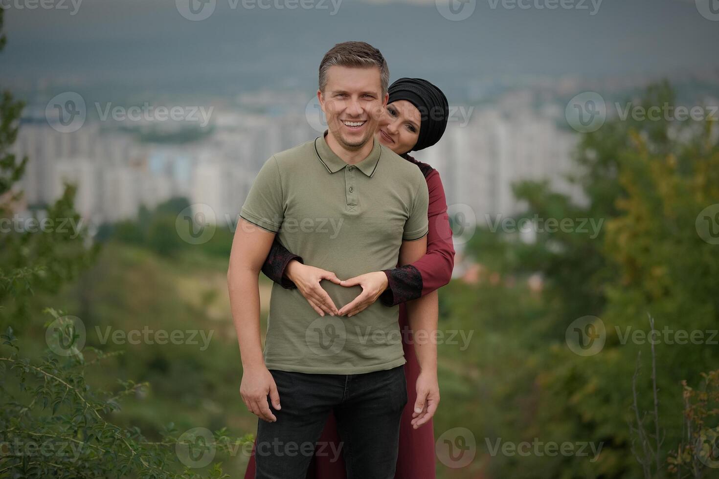 A young happy Muslim couple embracing, smiling wife hugging with love husband outdoor. photo