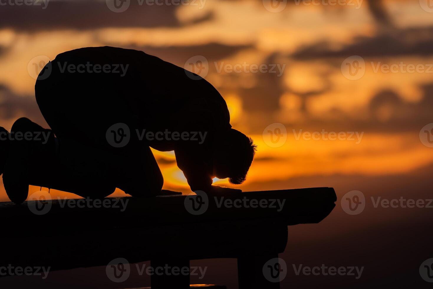 A Muslim prayer man praying at sunset. photo
