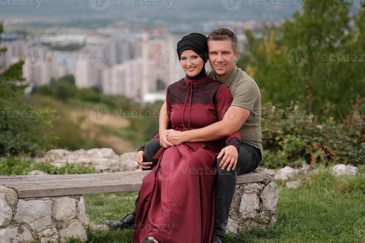 A happy Muslim couple young wife in hijab hugging her loving husband outside. photo