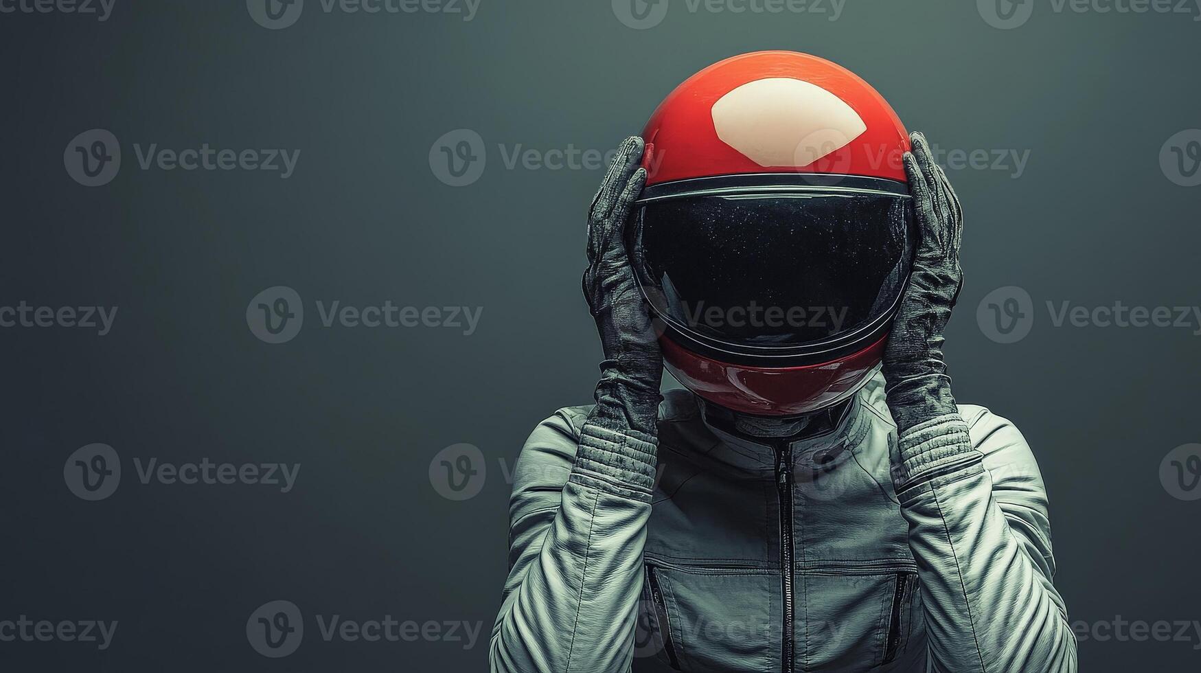 Pilot wearing helmet and gloves holding head on dark background photo