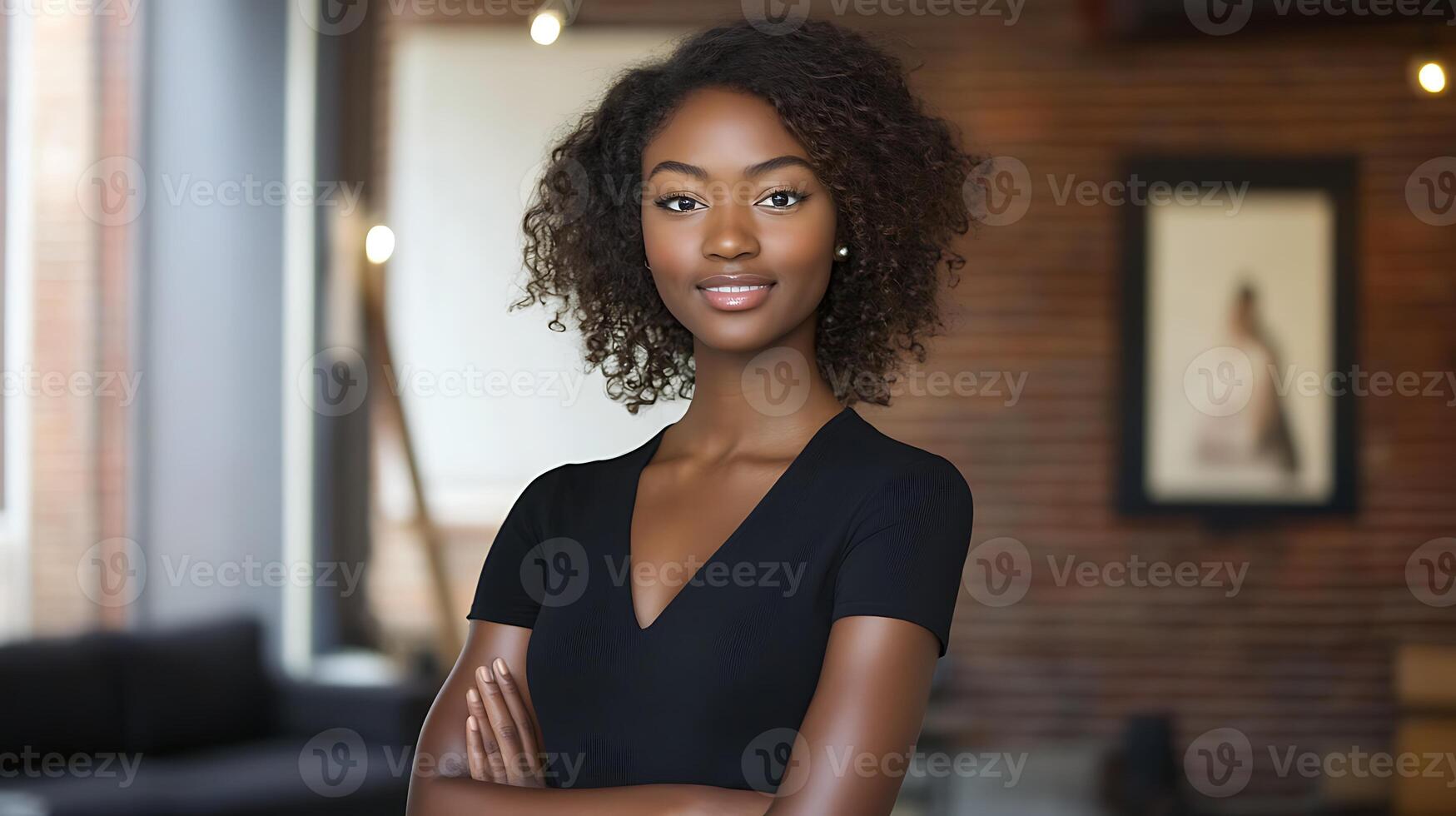 A beautiful young woman with curly hair standing in front of a brick wall photo