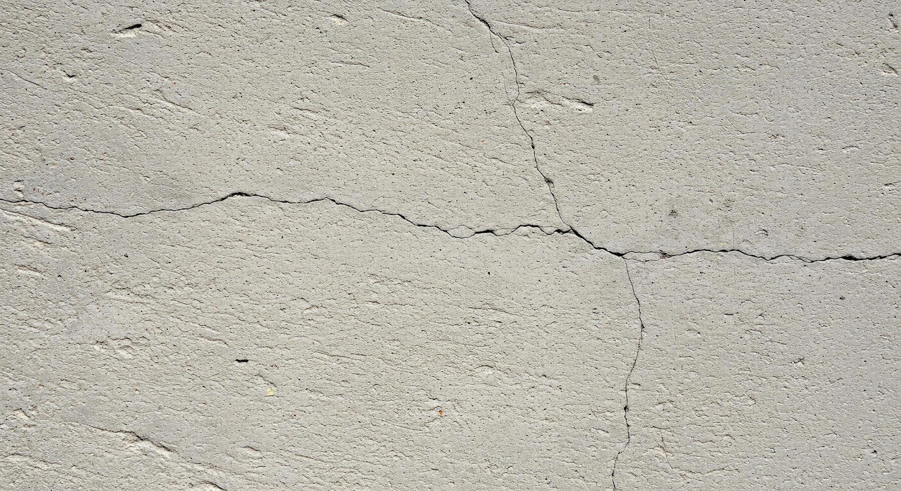 A crack in the concrete wall with a crack in the middle photo
