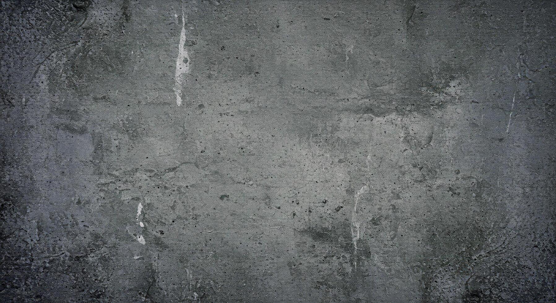 A black and white photo of a-gritty concrete wall texture with dark graytones subtle graffiti like stains and uneven surface textures