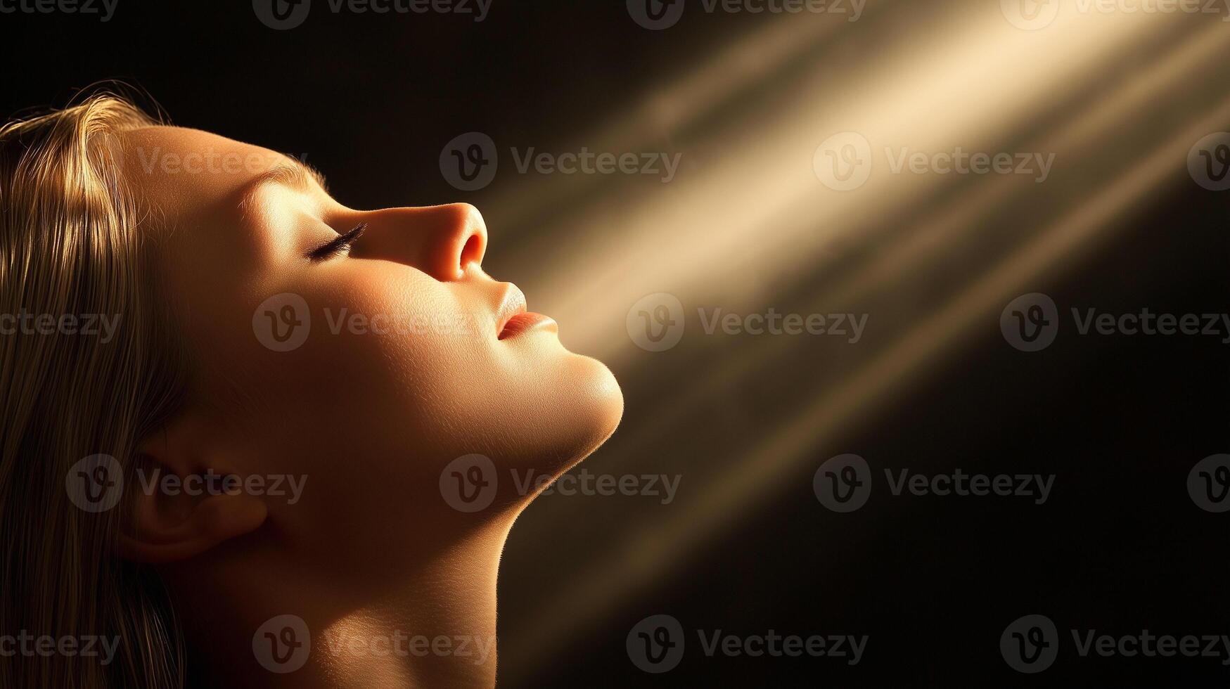 Woman feeling spirituality and enlightenment with divine light rays illuminating face photo