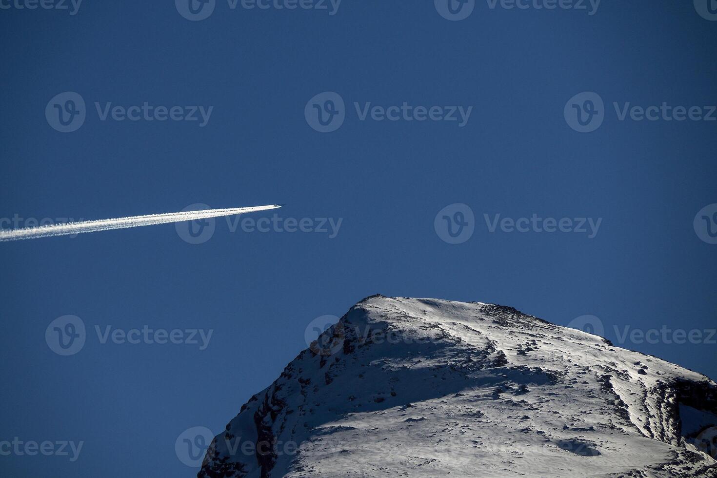 airplane jet flying over dolomites fanes pass mountain in winter snow season sunny day photo