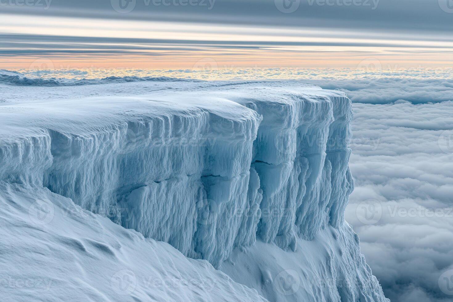 A large ice cliff with snow on top photo