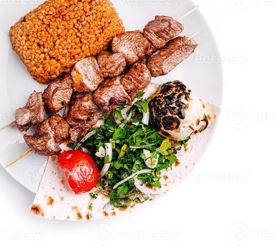 Savory grilled meat skewers with bulgur and fresh vegetables photo