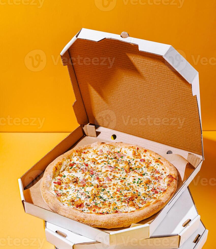 Delicious pizza served in a classic takeout box with bright background photo