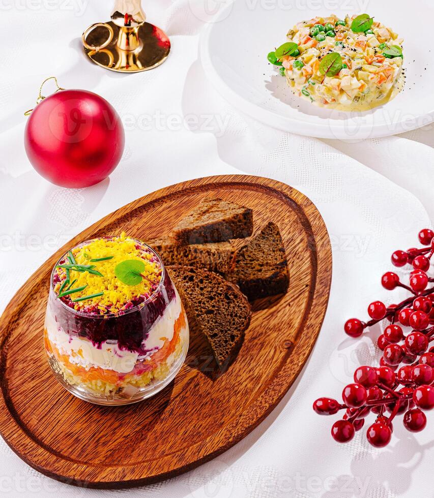 Tasty Olivier salad with boiled sausage on light gray table photo